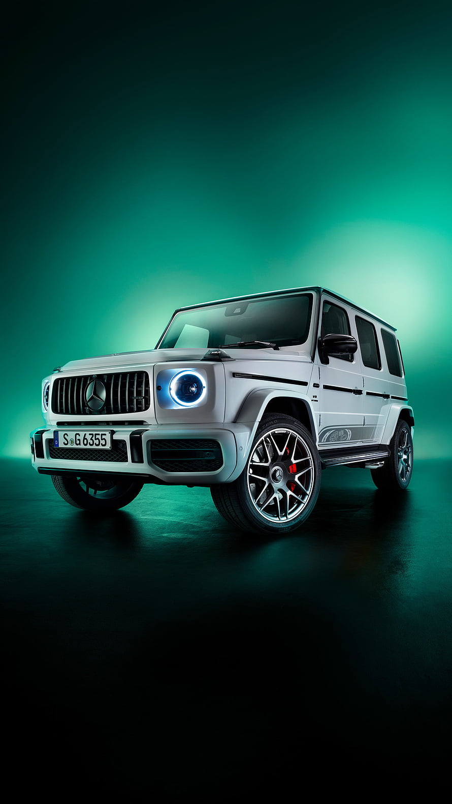 Silver Mercedes-AMG G-Class SUV with LED headlights on a dark teal studio background HD phone wallpaper