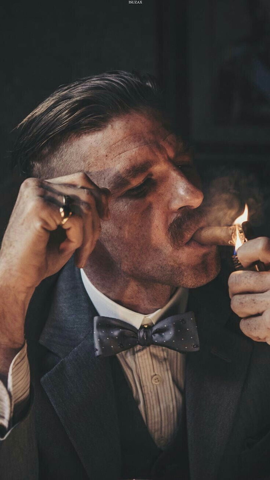 Arthur Shelby from Peaky Blinders lighting a cigar in a dark suit and bow tie HD phone wallpaper