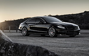 Black Mercedes-Benz CLS 63 AMG Sedan Parked on Gravel at Sunset HD wallpaper
