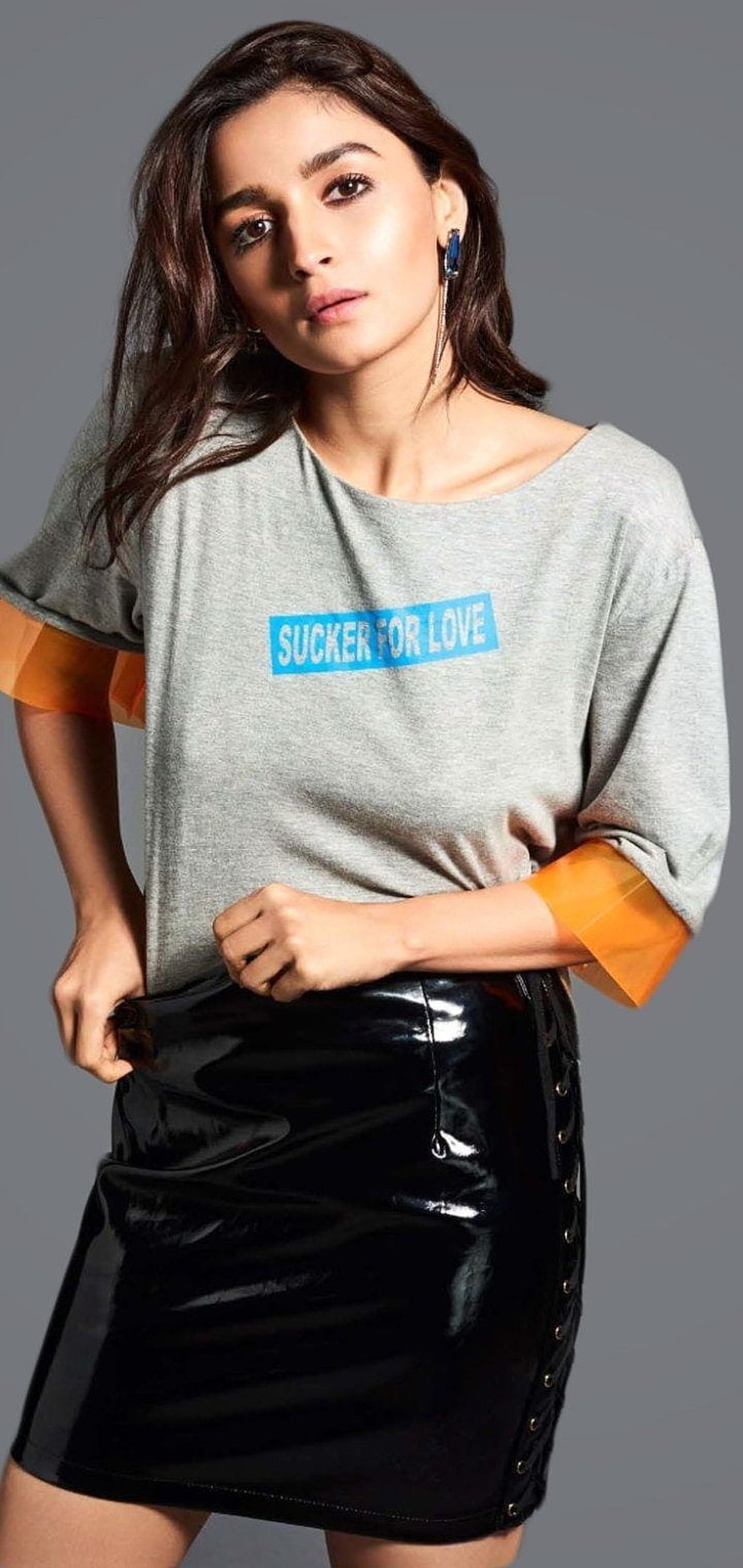 Stylish Woman in Grey Graphic Tee and Black Patent Leather Skirt HD phone wallpaper