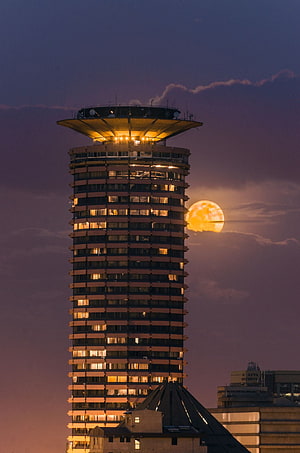 Nairobi City Skyline at Dusk with Full Moon Rising Behind Towering Skyscraper HD phone wallpaper