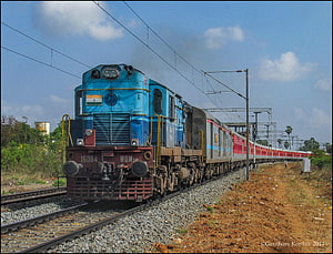 Blue Indian Railways Diesel Locomotive Pulling Passenger Coaches on Open Track HD wallpaper