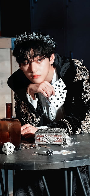 Kim Taehyung in ornate black baroque attire with playing cards, dice, and a jeweled crown HD phone wallpaper
