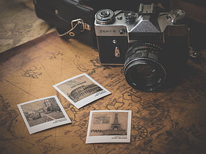 Zenit-E vintage film camera with instant photos on an antique world map HD wallpaper