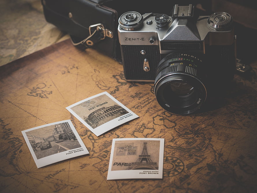 Zenit-E vintage film camera with instant photos on an antique world map HD wallpaper
