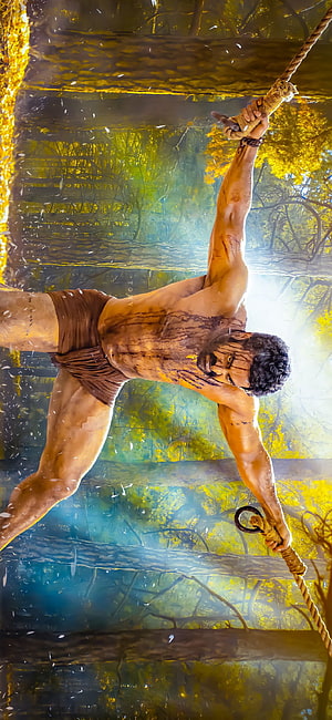 NTR as RRR Warrior Swinging on Rope in Jungle HD phone wallpaper