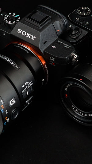 Sony Alpha 7R Mirrorless Camera with G Master Lens on Black Background HD phone wallpaper