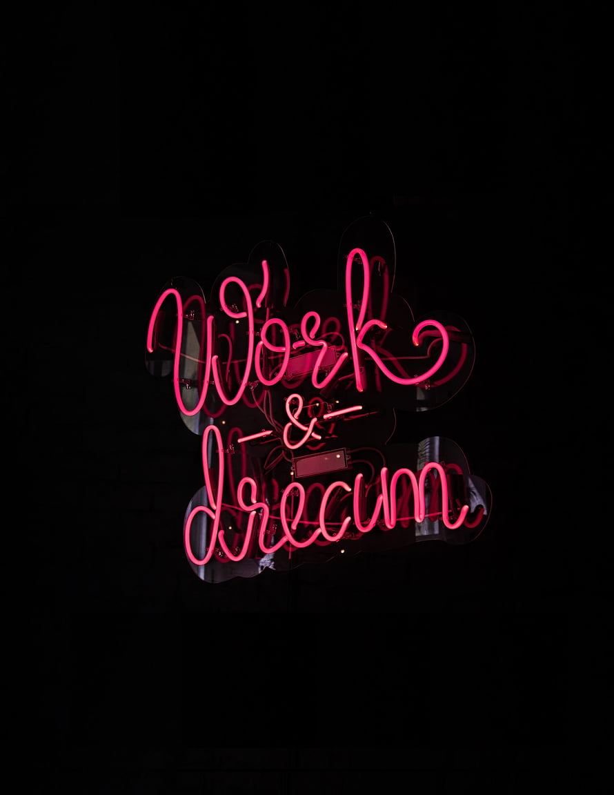 Glowing Pink Neon Sign Reading Work and Dream on a Dark Black Background HD phone wallpaper