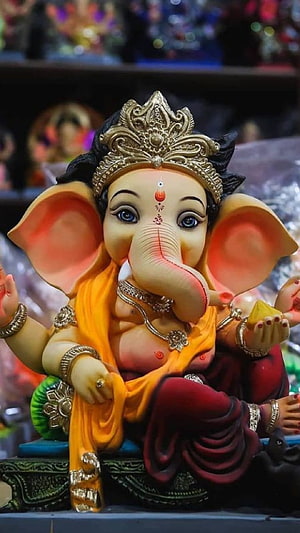 Cute Ganesha Idol Wearing Golden Crown and Orange Saree with Red Drape HD phone wallpaper