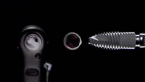 Close-up of dental implant components and surgical tools on a black background HD wallpaper