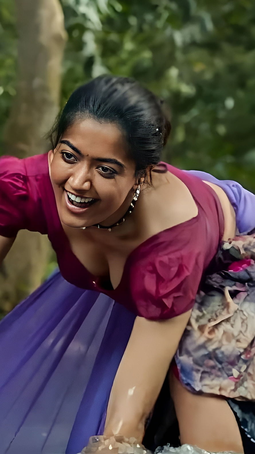 Rashmika Mandanna in a vibrant magenta and purple outfit smiling outdoors HD phone wallpaper