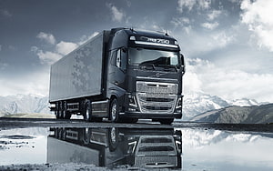 Volvo FH16 750 Heavy Duty Truck Parked on Wet Gravel with Mountain Reflection HD wallpaper