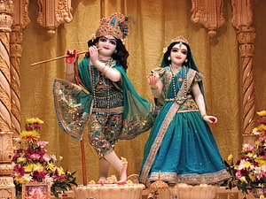Radha Krishna Temple Deities in Ornate Green Attire with Floral Arrangements HD wallpaper