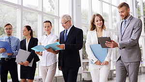 Professional business team collaborating in a modern office with documents and tablets HD wallpaper
