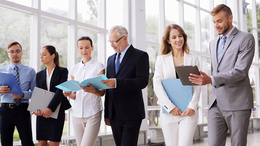 Professional business team collaborating in a modern office with documents and tablets HD wallpaper