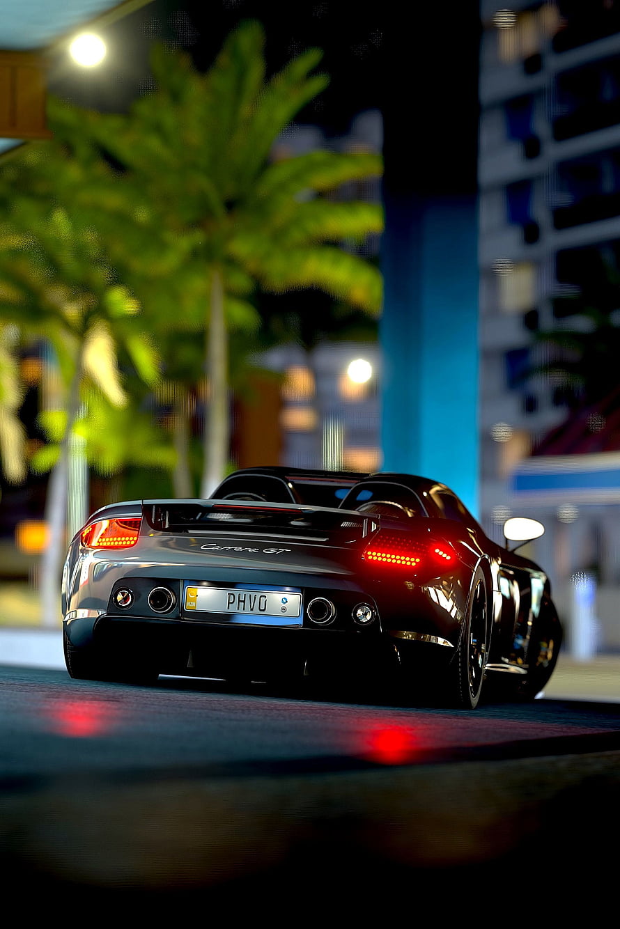 Porsche Carrera GT Rear View at Night with Glowing Taillights and Urban Palm Trees HD phone wallpaper