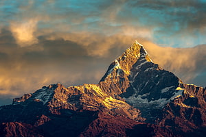 Annapurna Peak in the Himalayas at Golden Hour with Dramatic Clouds HD wallpaper