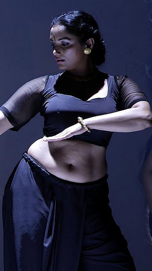 Swetha Menon in a dramatic black dance costume with expressive hand gestures HD phone wallpaper