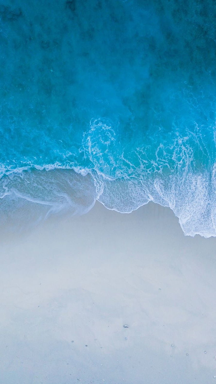 Aerial View of Turquoise Ocean Waves Lapping Against White Sandy Shore HD phone wallpaper