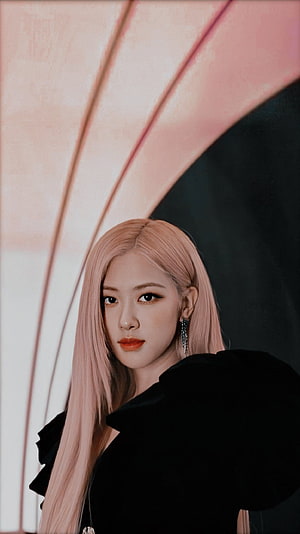 Rosé from Blackpink with long pink hair in a black outfit against a soft pink and dark background HD phone wallpaper