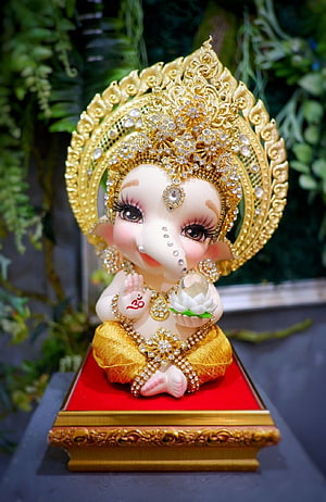 Adorned Baby Ganesha Statue with Golden Crown and Lotus Flower HD phone wallpaper