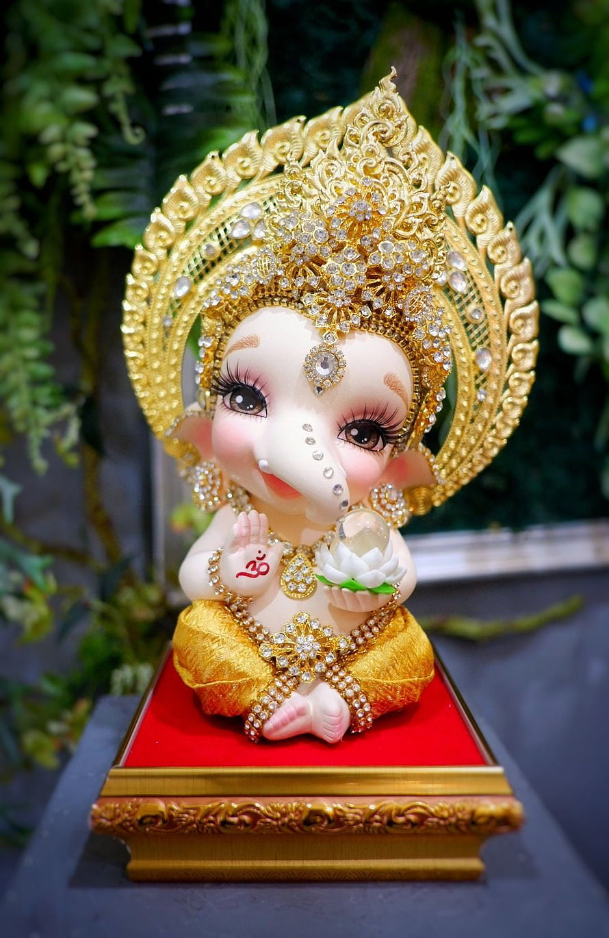 Adorned Baby Ganesha Statue with Golden Crown and Lotus Flower HD phone wallpaper
