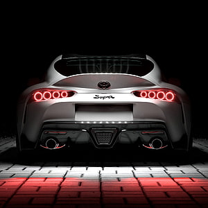 Rear View of a Silver Toyota Supra with Glowing Red Taillights on a Brick Surface HD phone wallpaper