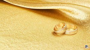 Elegant Gold Wedding Bands on Luxurious Silk Fabric HD wallpaper