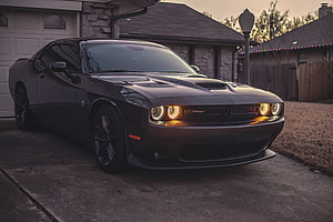 Black Dodge Challenger SRT Hellcat Parked in a Residential Driveway at Dusk HD wallpaper