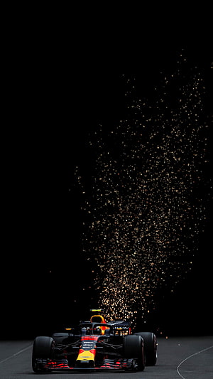 Red Bull Racing Formula 1 car emitting sparks on a dark track at night HD phone wallpaper