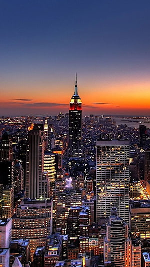 New York City Skyline at Dusk with Empire State Building Illuminated Against Orange Sunset HD phone wallpaper