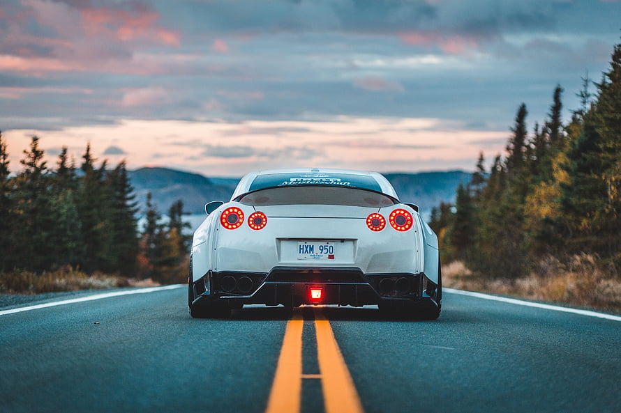 White Nissan GT-R Rear View on Mountain Road at Sunset HD wallpaper