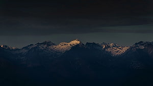 Snow-Capped Mountain Range Under Dramatic Twilight Sky HD wallpaper
