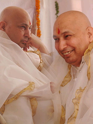 Bald Spiritual Leader in White Robes with Gold Trim and Red Tilak HD phone wallpaper