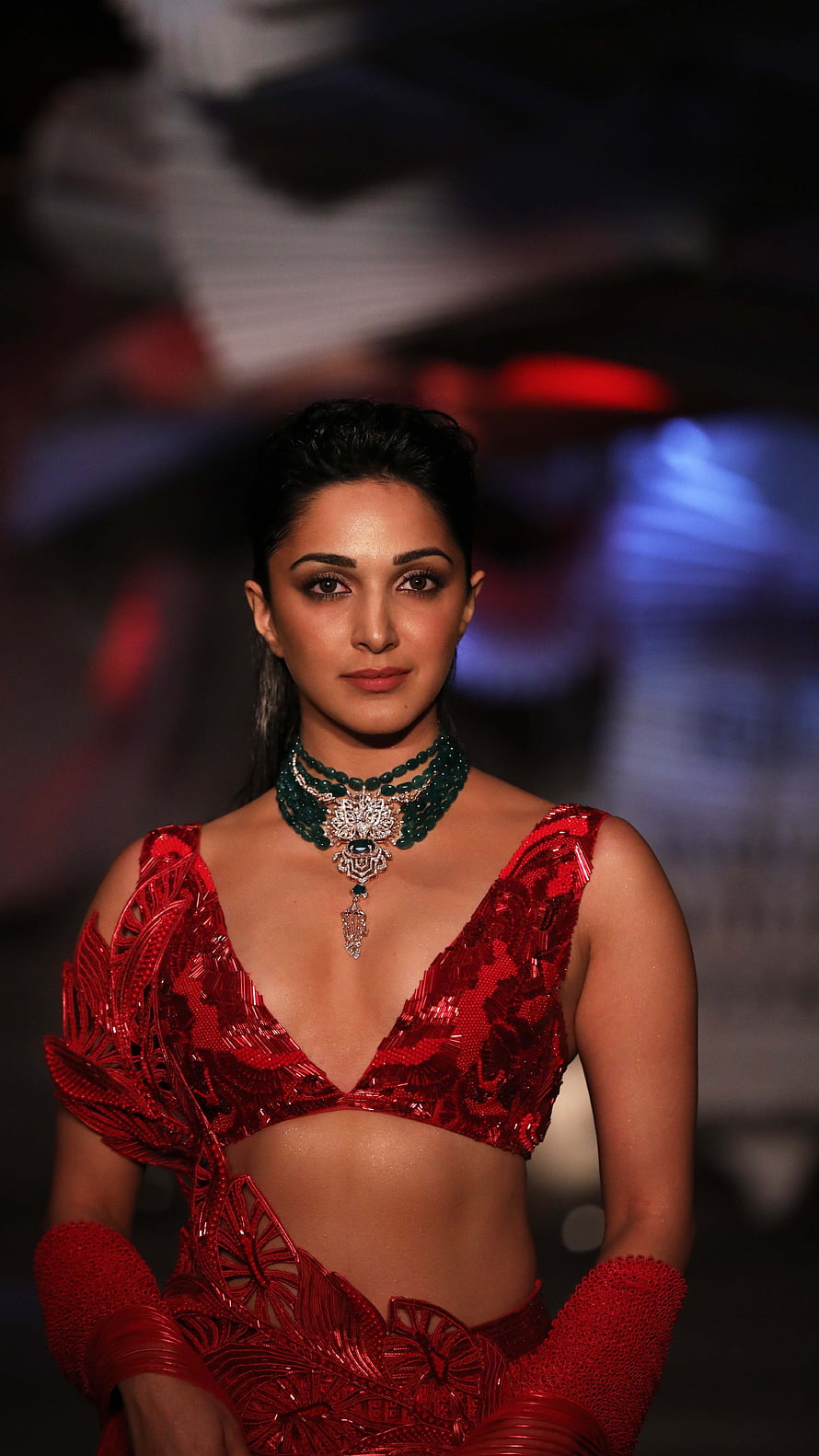 Kiara Advani in a red sequined two-piece outfit with emerald and diamond jewelry on a fashion runway HD phone wallpaper