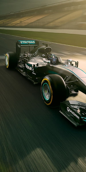 Mercedes-AMG Petronas Formula 1 car speeding on a racetrack with motion blur and teal livery HD phone wallpaper