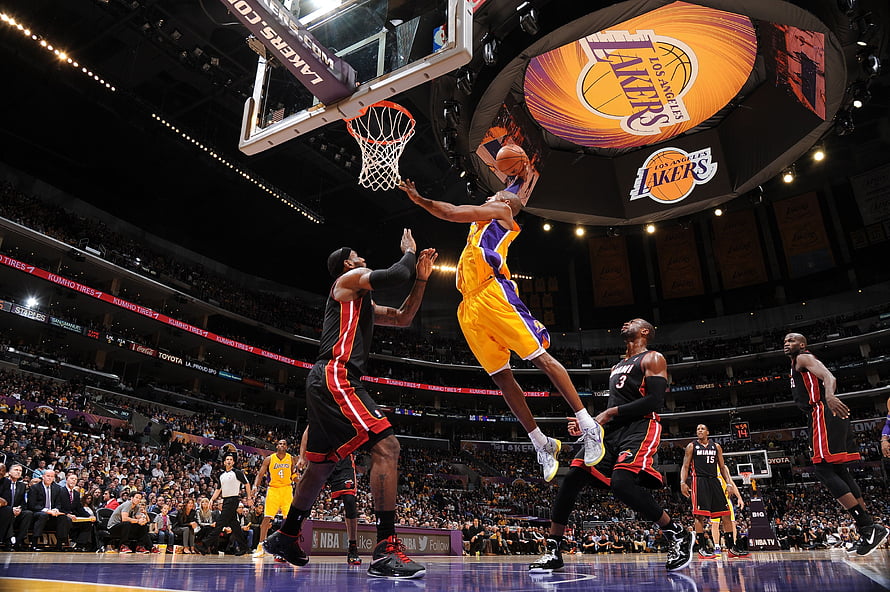 Kobe Bryant dunking over a defender during a Los Angeles Lakers NBA game HD wallpaper