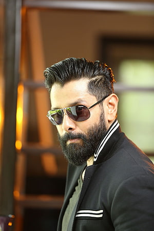Vikram in Iru Mugan wearing aviator sunglasses and a black bomber jacket with a full beard HD phone wallpaper