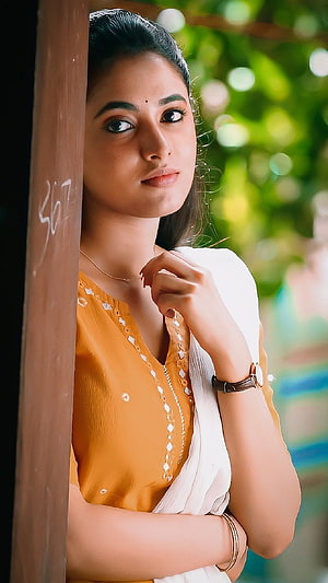 Priyanka Mohan in Traditional Saree Leaning Against Wooden Pillar HD phone wallpaper