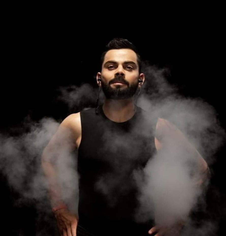 Virat Kohli in Black Tank Top with Dramatic Smoke Effect on Dark Background HD phone wallpaper