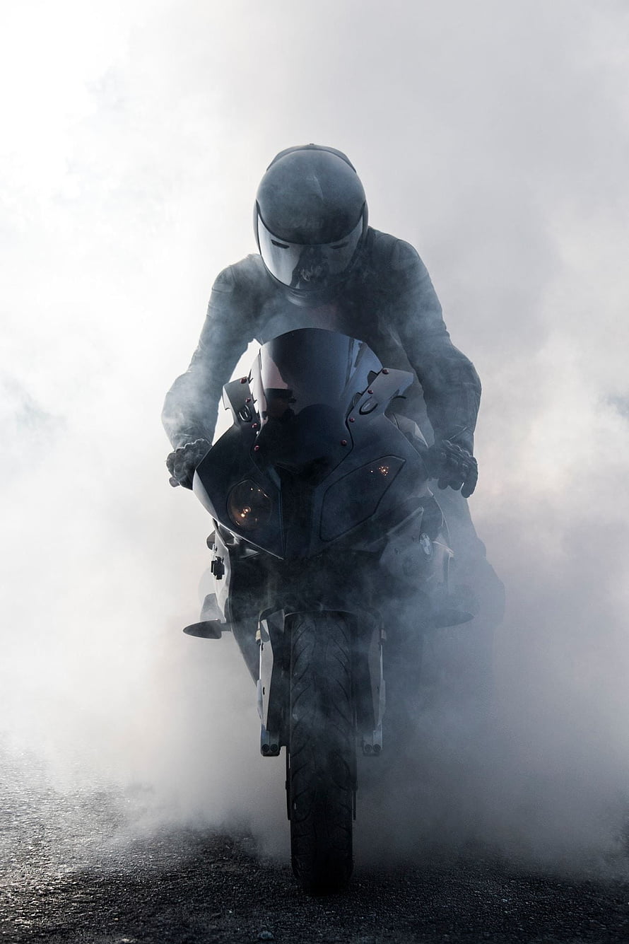Rider on a Black BMW S1000RR Sportbike Emerging Through Thick Fog HD phone wallpaper