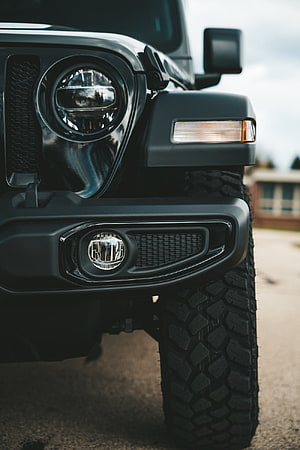 Close-Up of Black Jeep Wrangler Front Bumper, Headlight, and Off-Road Tire HD phone wallpaper