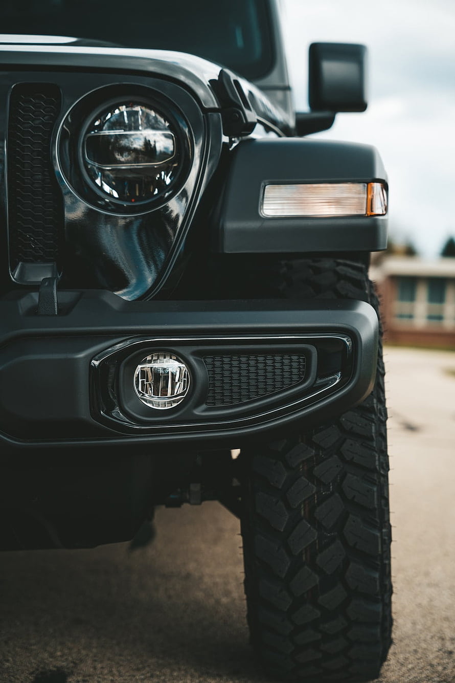 Close-Up of Black Jeep Wrangler Front Bumper, Headlight, and Off-Road Tire HD phone wallpaper