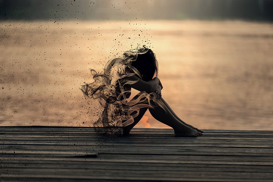 Silhouette of a Crouching Woman Dissolving Into Smoke on a Wooden Pier at Sunset HD wallpaper
