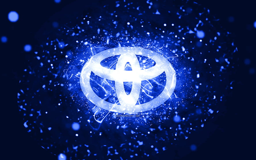 Glowing Toyota emblem surrounded by electric blue particles and neon light effects on a dark abstract background HD wallpaper