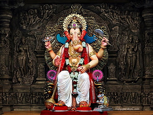 Ganesha seated on ornate throne with traditional garlands and sacred symbols in dark temple setting HD wallpaper