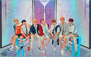 BTS Members Sitting on Blue Bench in Colorful Studio Setting HD wallpaper