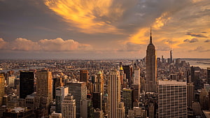 New York City Skyline at Golden Hour with Empire State Building and Dramatic Clouds HD wallpaper