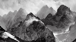 Monochrome Snow-Capped Alpine Peaks with Dramatic Clouds and Mist HD wallpaper
