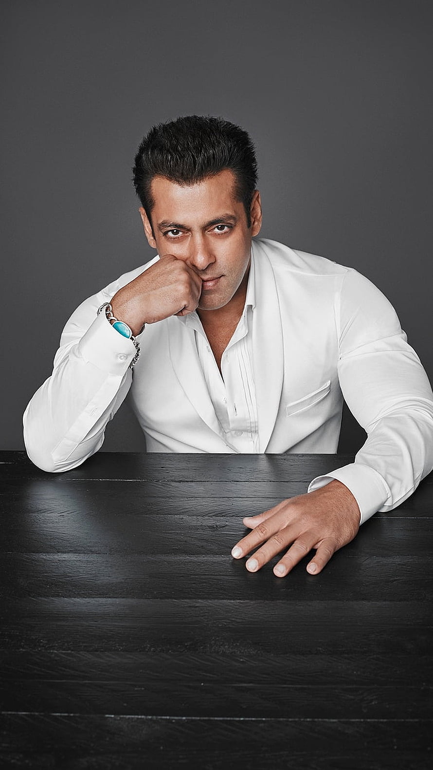 Salman Khan in White Shirt Leaning on Dark Table with Intense Gaze HD phone wallpaper